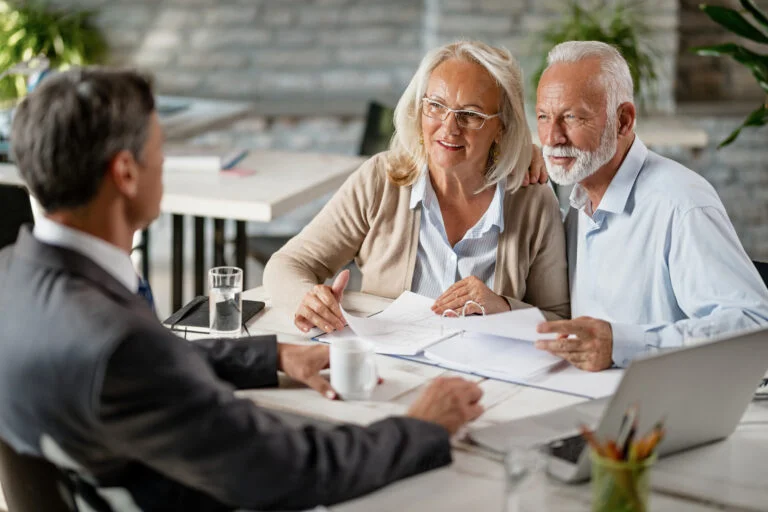 Happy Senior Couple Going Through Blueprints While Talking With