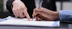 Patient Filling In Report Papers At Reception